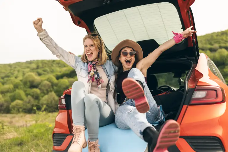 two women celebrate a carefree road trip.