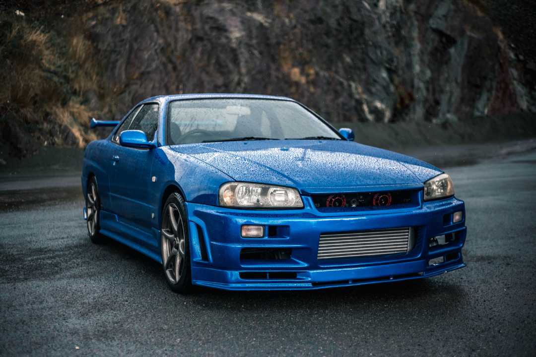 Glossy blue sports car on rainy highway, front angle view highlighting its beauty and road-readiness for car registration USA.
