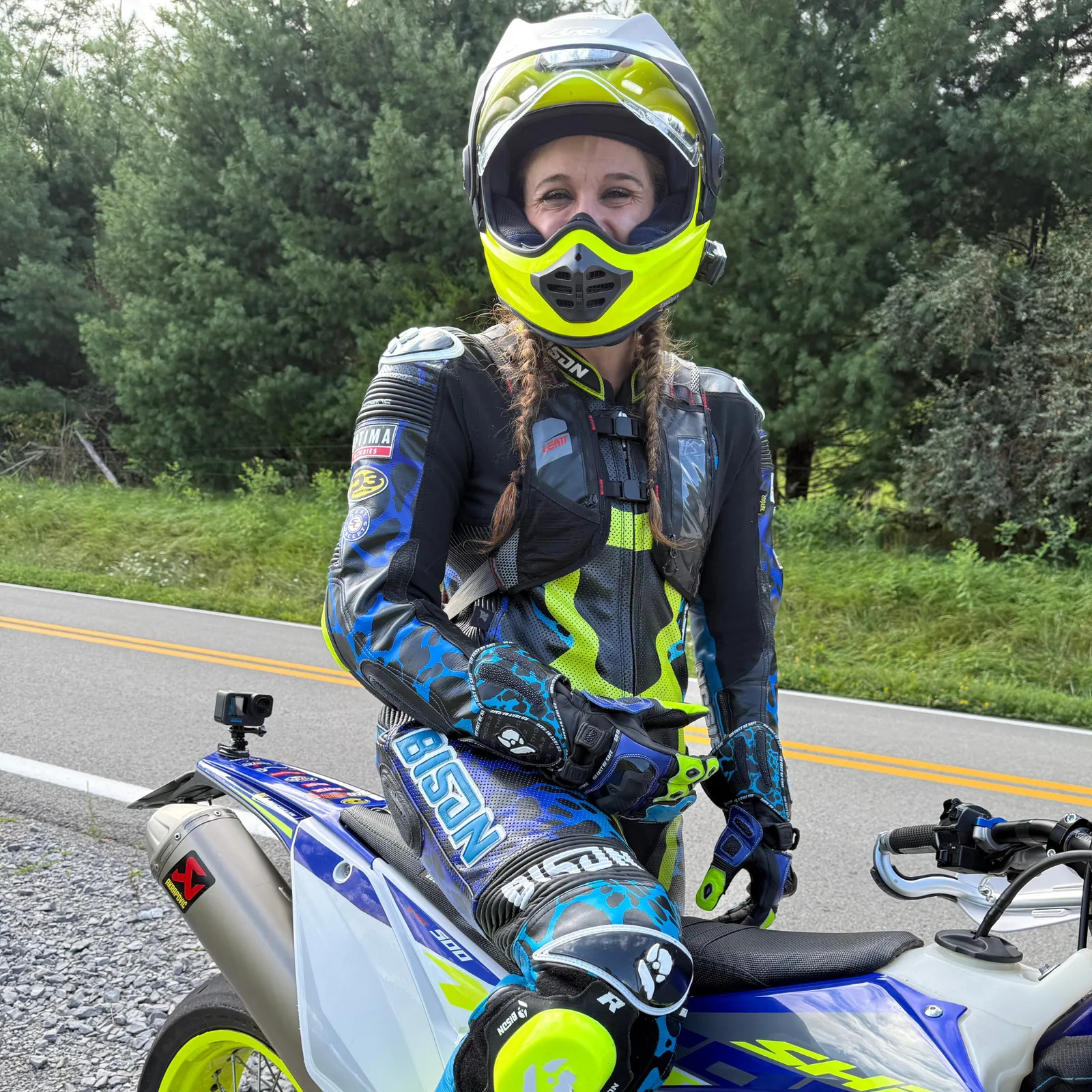 Crystalmarie in full riding gear and helmet beside her Sherco 250 SE on a rural road