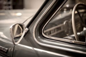 Classic car chrome mirror and trim details reflect ownership and vehicle documentation requirements