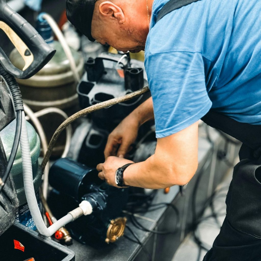 Mechanic inspecting car engine components during routine maintenance service at auto repair shop