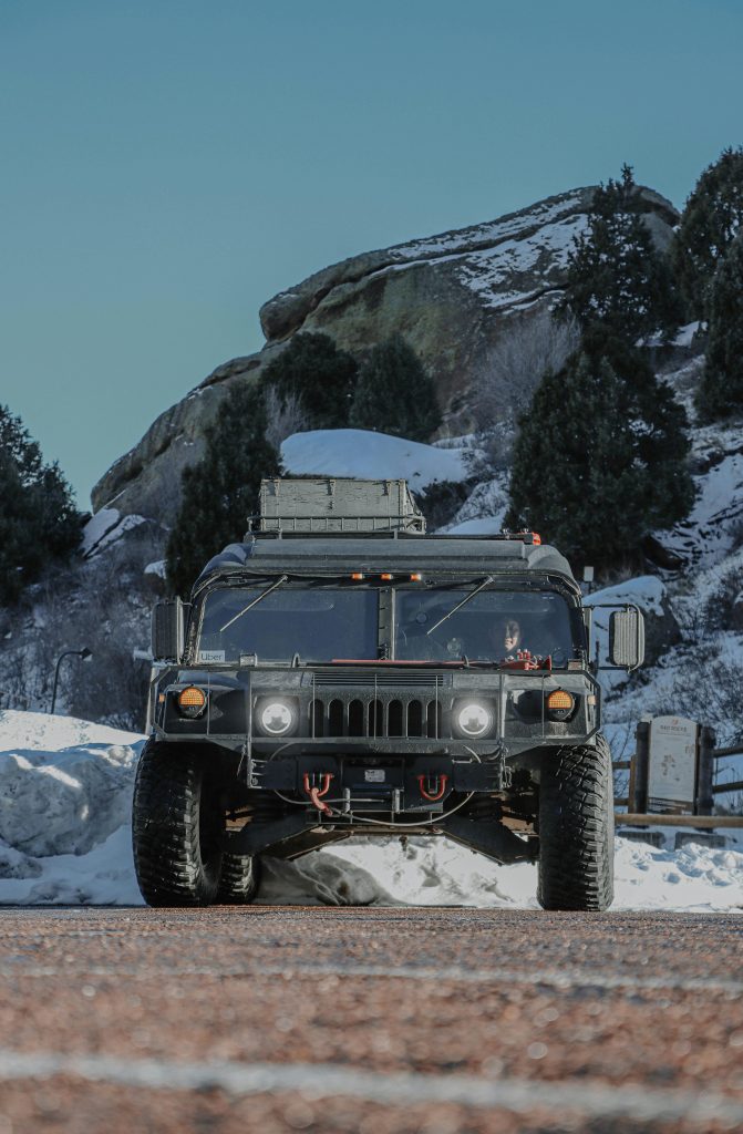 Military Humvee truck stuck in snow-covered mountain terrain facing vehicle registration problems