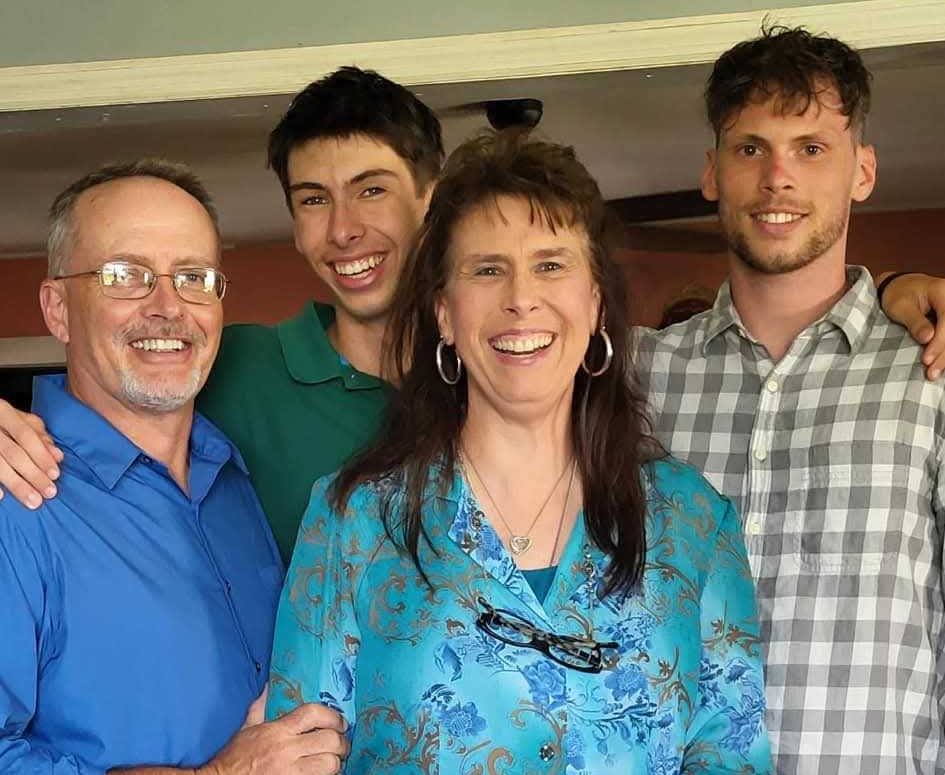 Four smiling family members pose together indoors, honoring beloved Dirt Legal team member Caleb's memory and legacy