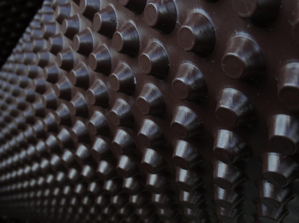 Close-up of textured tire tread pattern showing deep grooves and ridges for optimal road grip and durability.