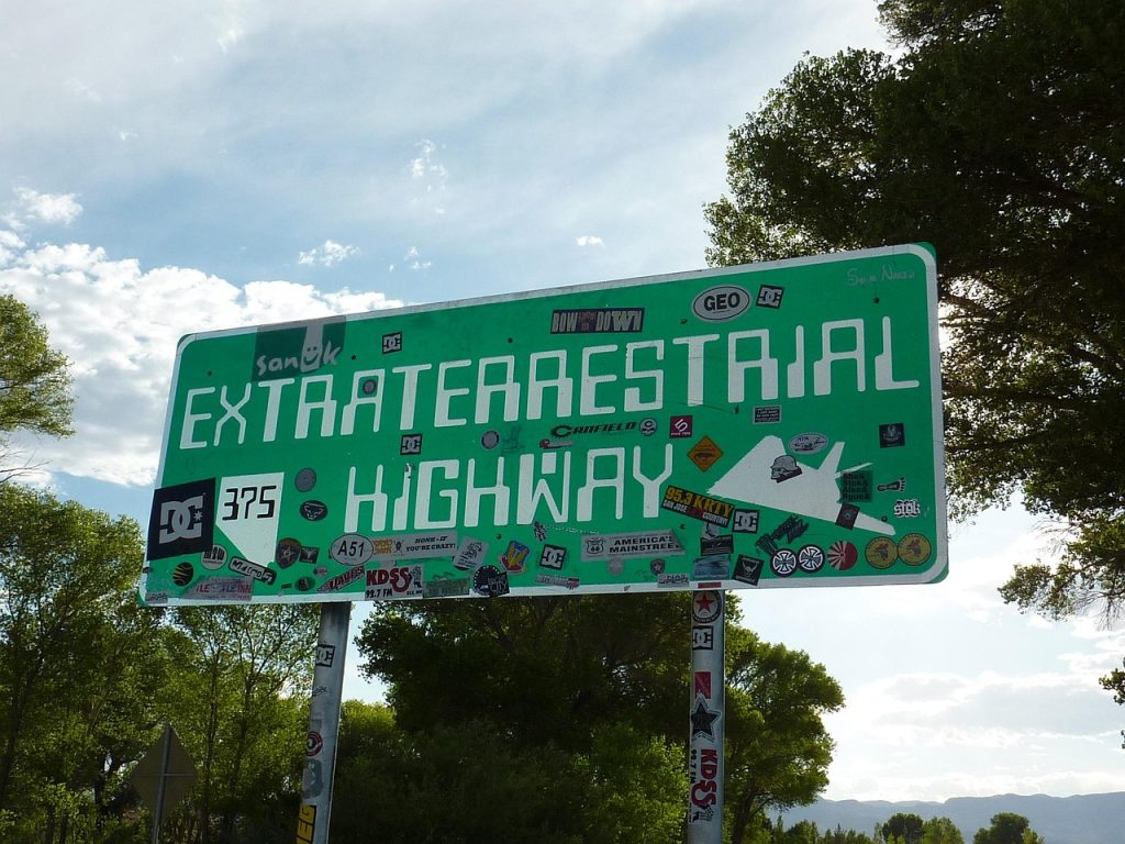Extraterrestrial Highway roadside sign with UFO artwork and sponsor logos on Nevada Route 375