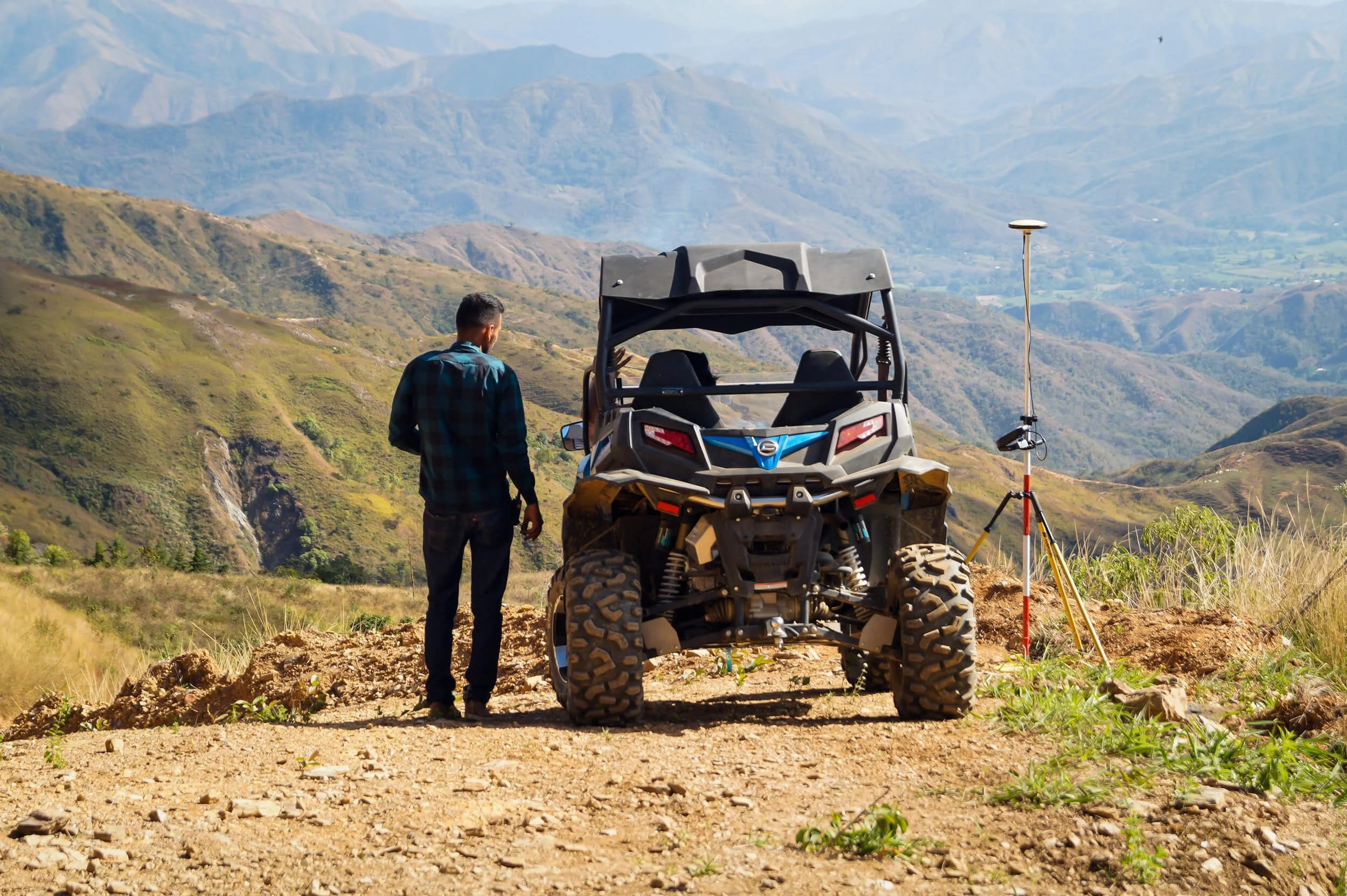 man standing beside UTV