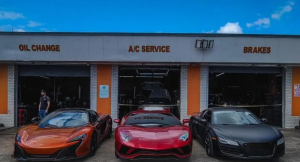 Auto repair shop with three sports cars parked outside service bays