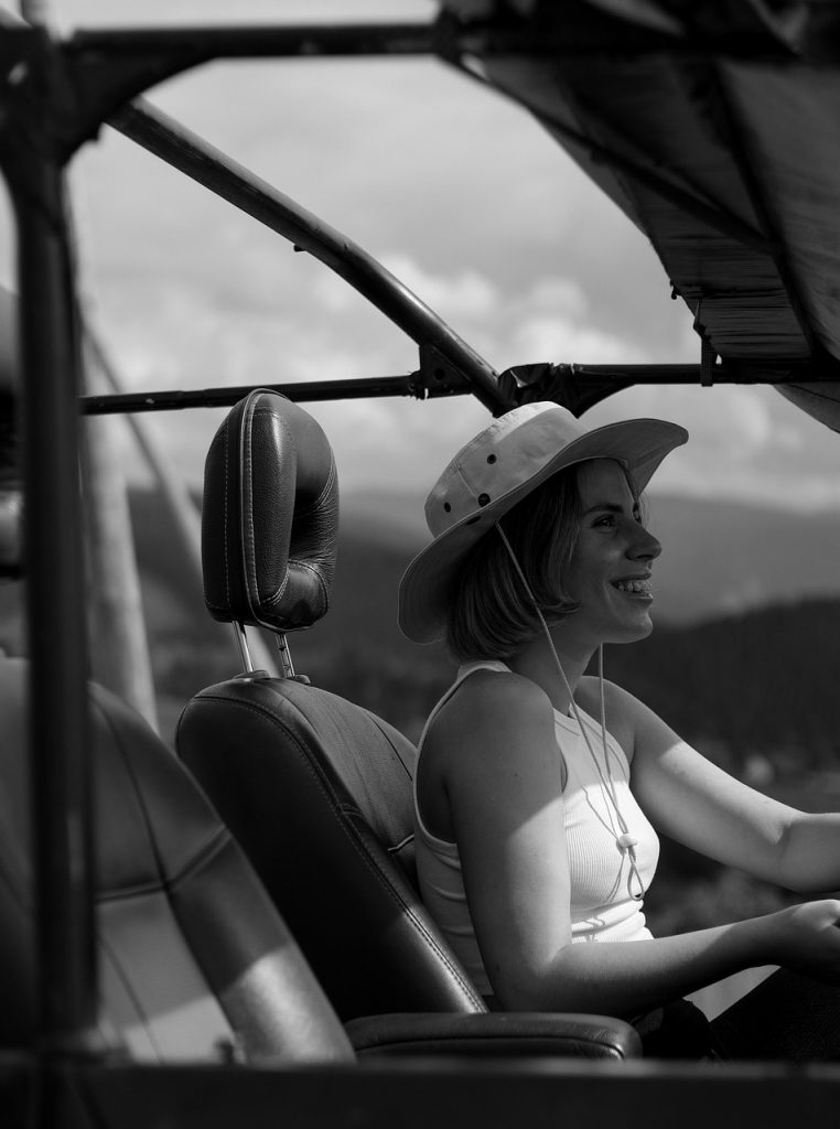 Woman driving convertible with freedom and joy, representing automotive independence and vehicle ownership liberty