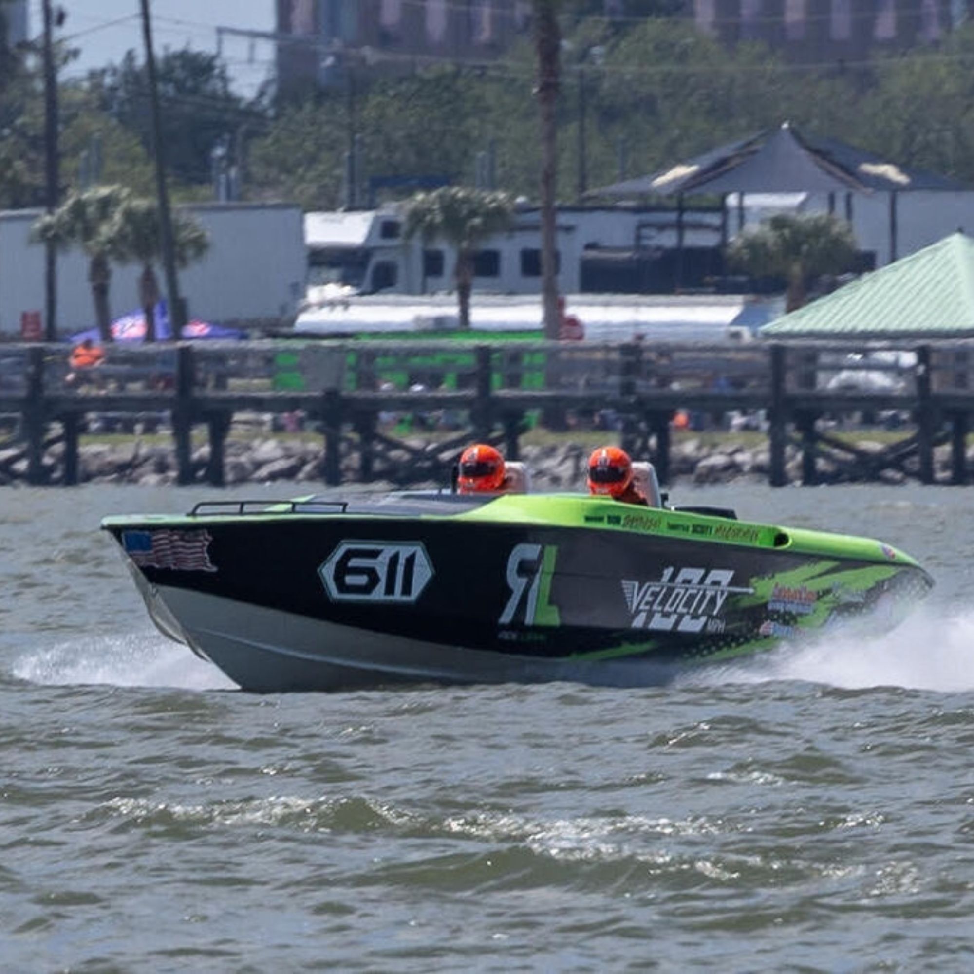 Orange offshore powerboat racing through white water spray at high speed during Clearwater Nationals competition