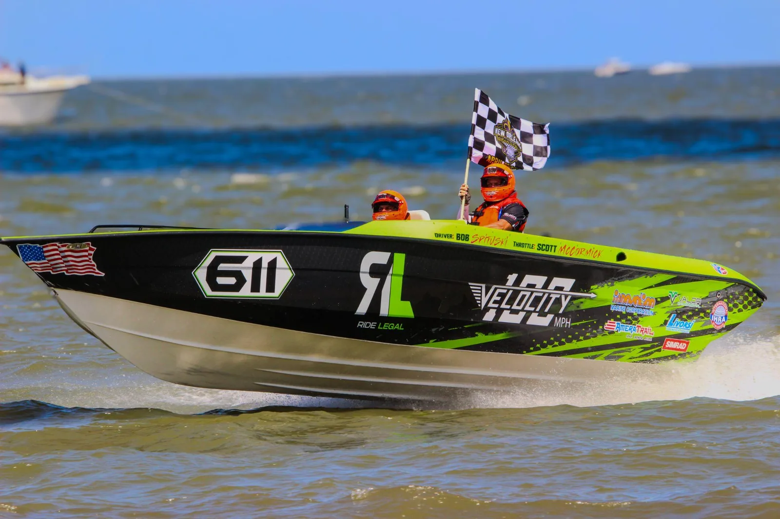 Ride Legal Velocity VR1 speedboat with checkered flag at beach, pursuing 100 MPH speed record attempt