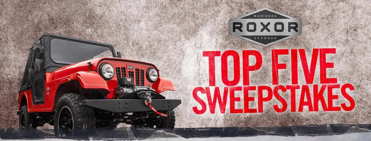 Red Mahindra Roxor off-road vehicle displayed against textured wall promoting Top Five Sweepstakes contest winner