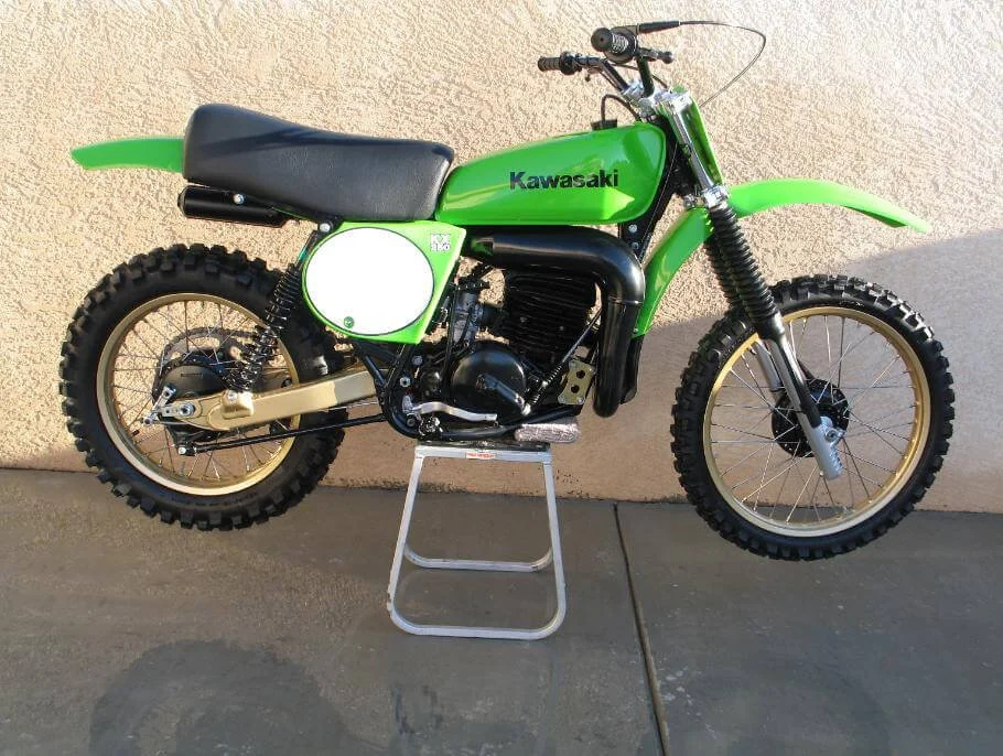 Vintage green Kawasaki dirt bike on display stand, classic rare motorcycle from motorcycle history era