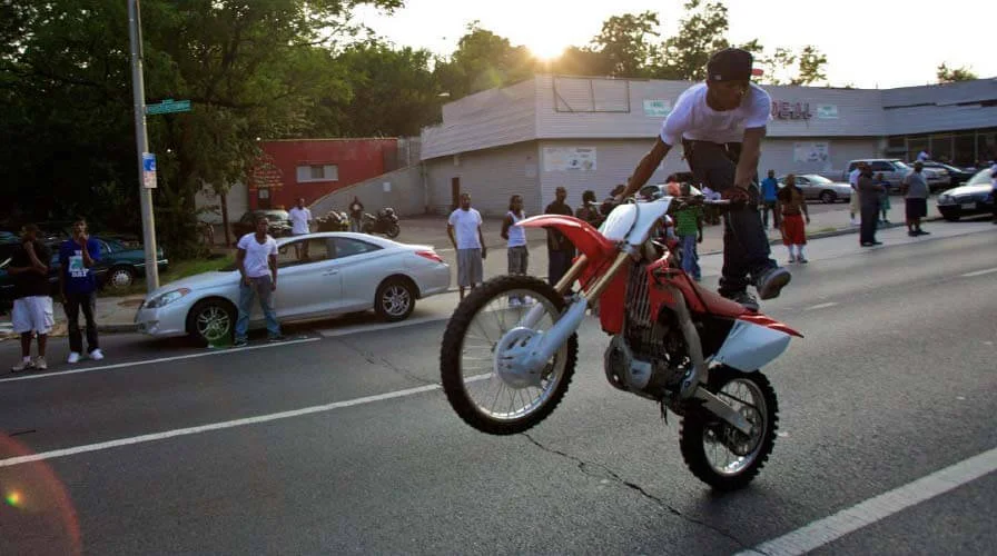 dirt bike wheelie on city street