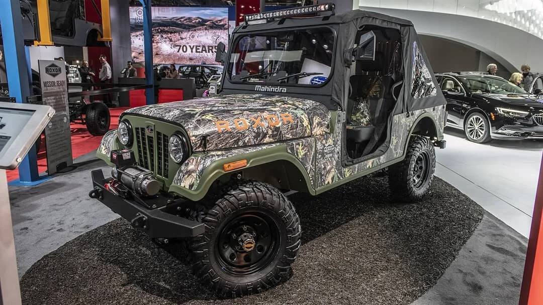 Camouflage-wrapped Mahindra Roxor UTV on display at auto show inspiring enthusiasts with rugged adventure capabilities.