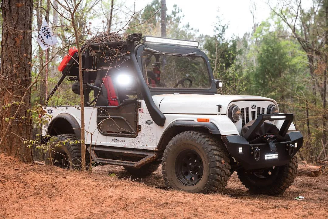 White Roxor off-road vehicle parked in forest clearing with open door, Black Friday street legal title promotion