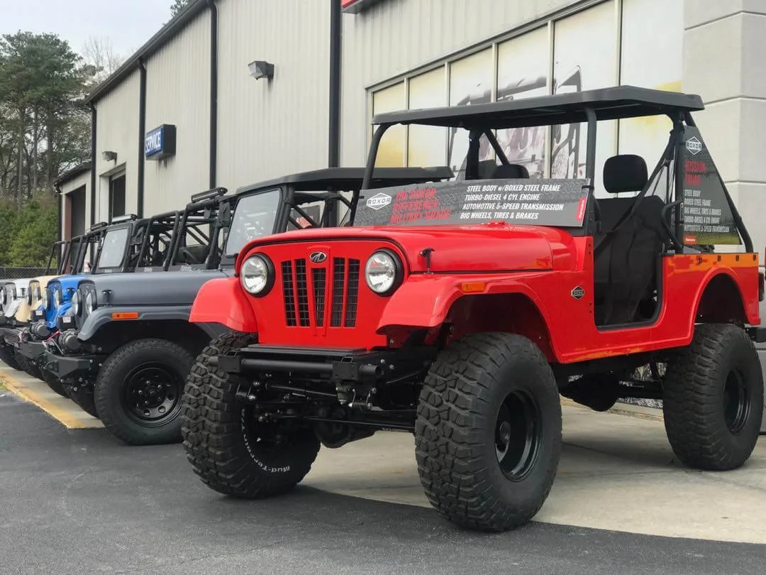 Red and black Roxor off-road vehicles displayed outside shop showcasing custom skid plates and grilles upgrades.