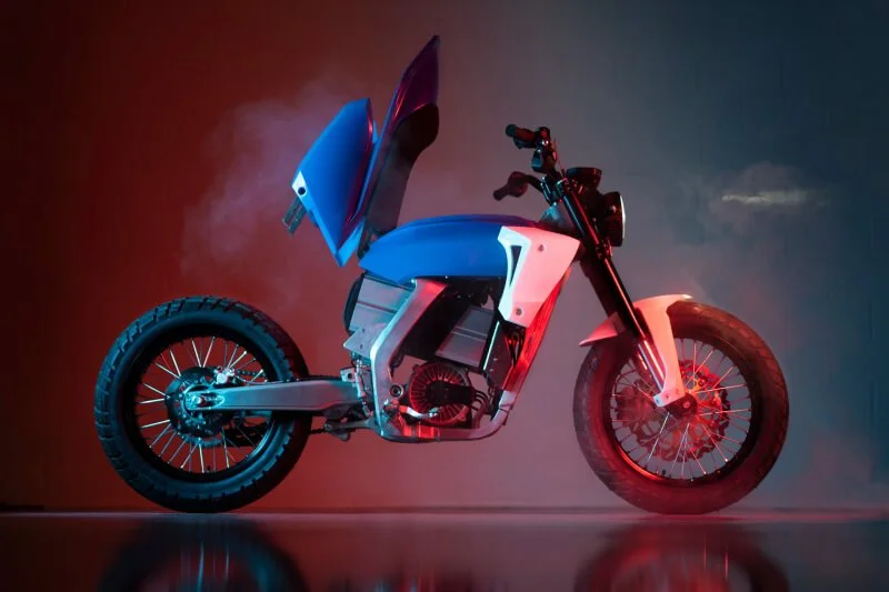 Futuristic red and blue electric motorcycle concept with sleek design against colorful gradient background lighting