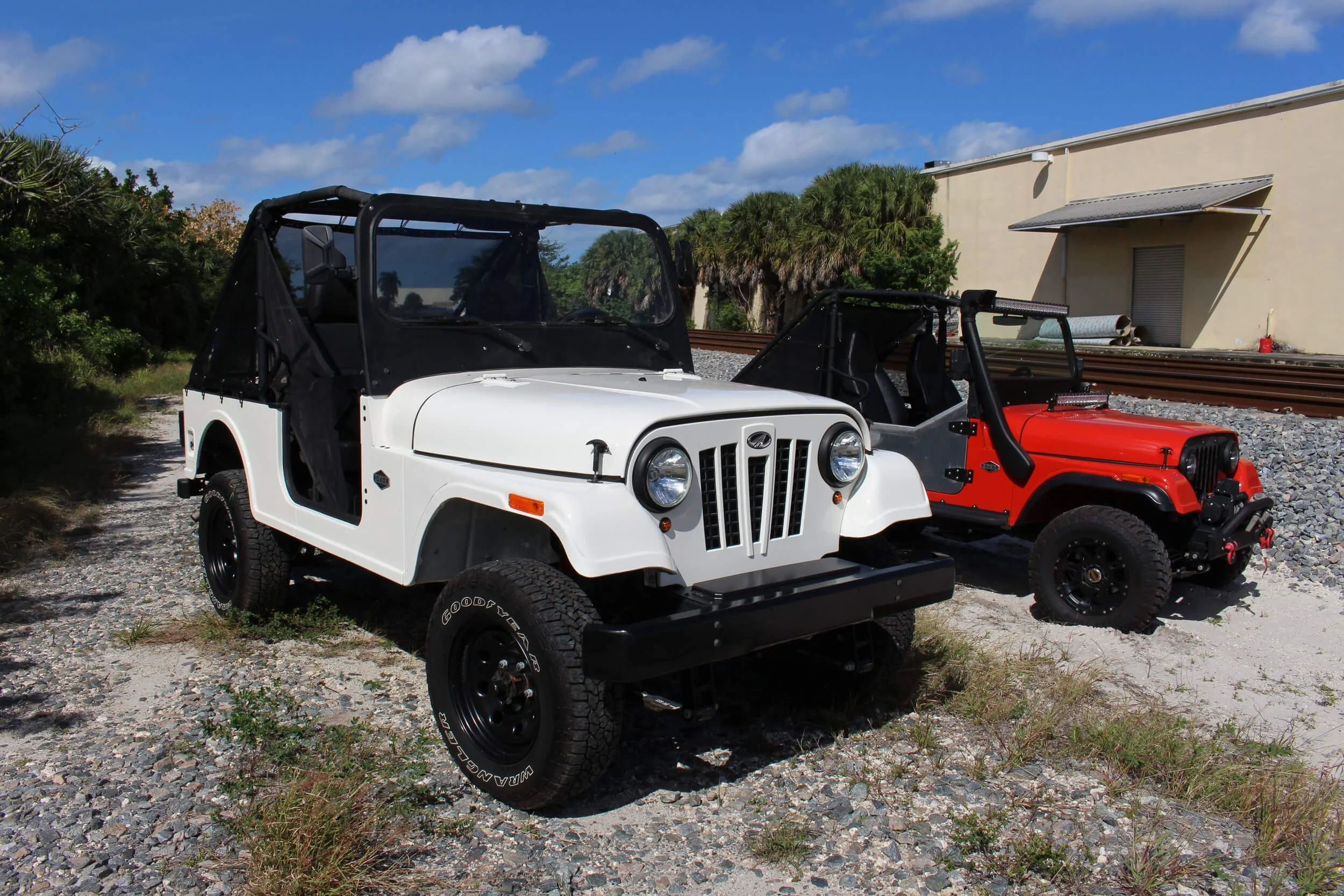 Two restored Jeeps display salvage vehicle rebuilding, illustrating Minnesota title risks with clean title vehicles.