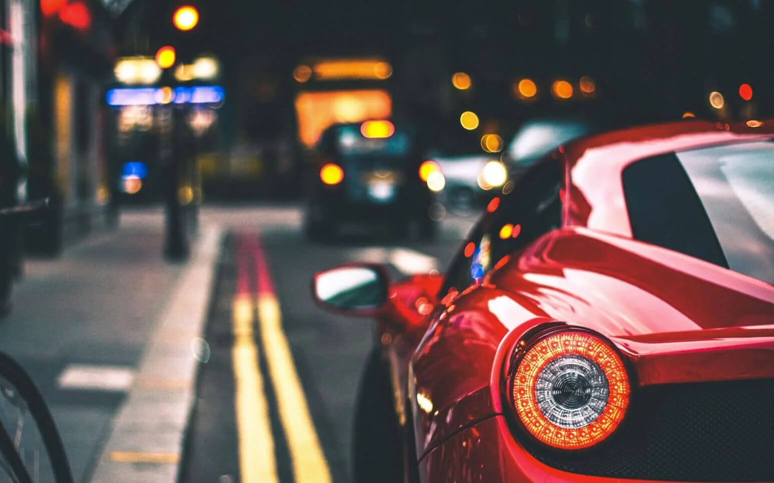 Red car parked on nighttime city street with mechanic's lien concept representing vehicle hold for unpaid repair charges