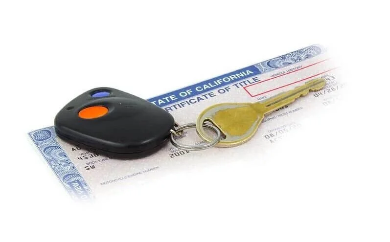 Car key with remote fob on California certificate of title and vehicle documentation for estate sale transfer