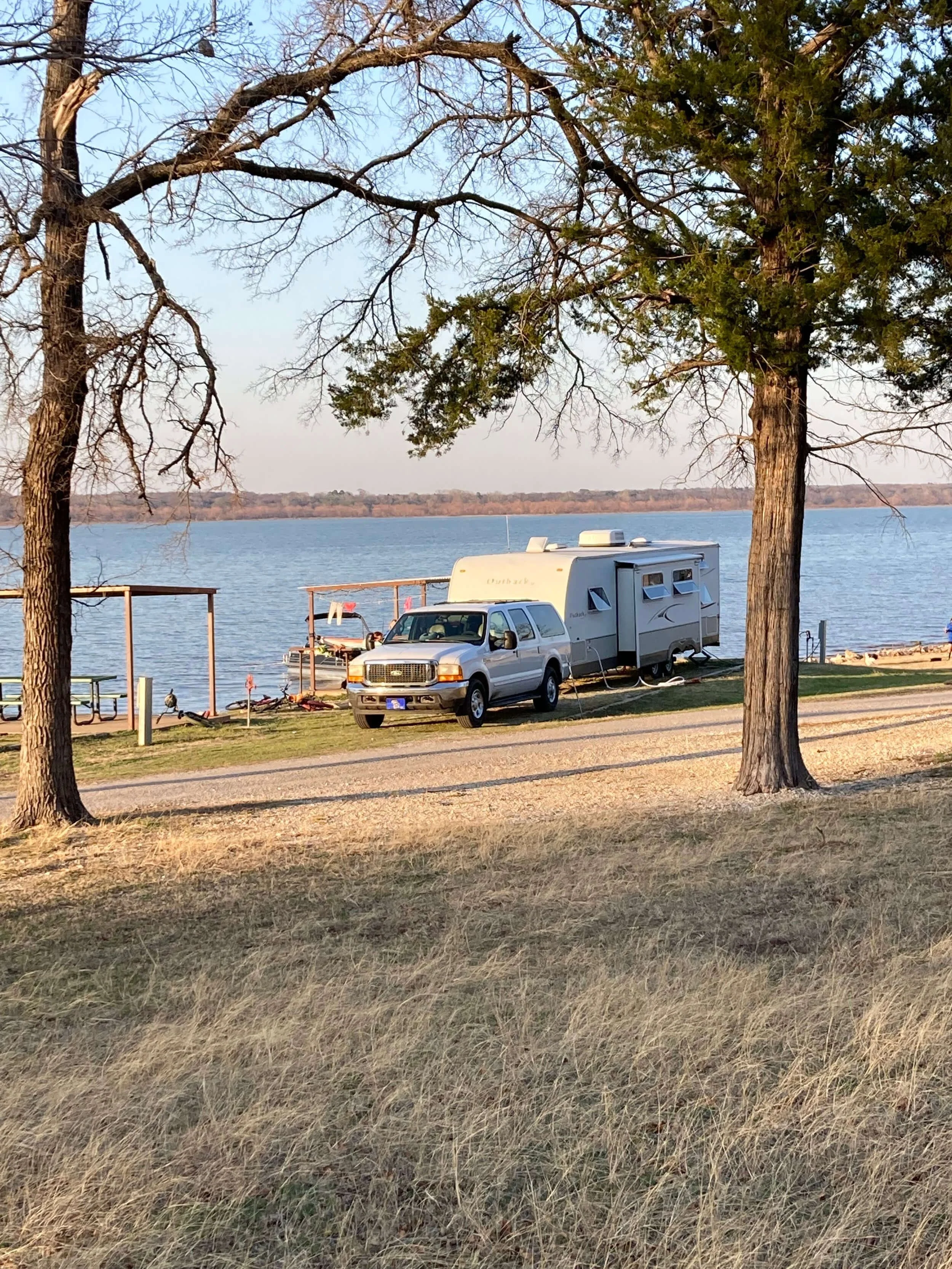 Recreational vehicle and towing car parked at lakeside campground