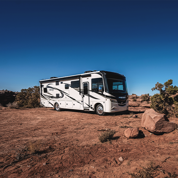 White Class A motorhome parked in desert terrain, illustrating RV driving licensing requirements and CDL regulations