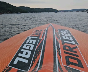 Orange speedboat with Velocity Punisher branding on calm lake waters during daytime