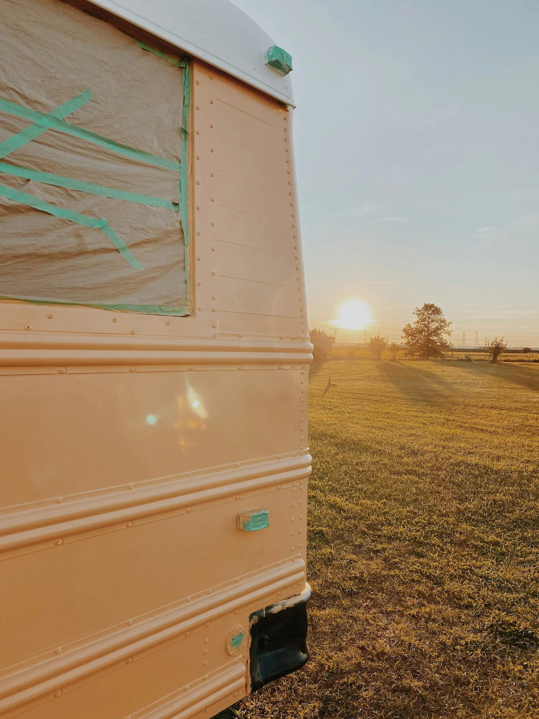 Vintage horse trailer parked in rural Montana pasture at sunset