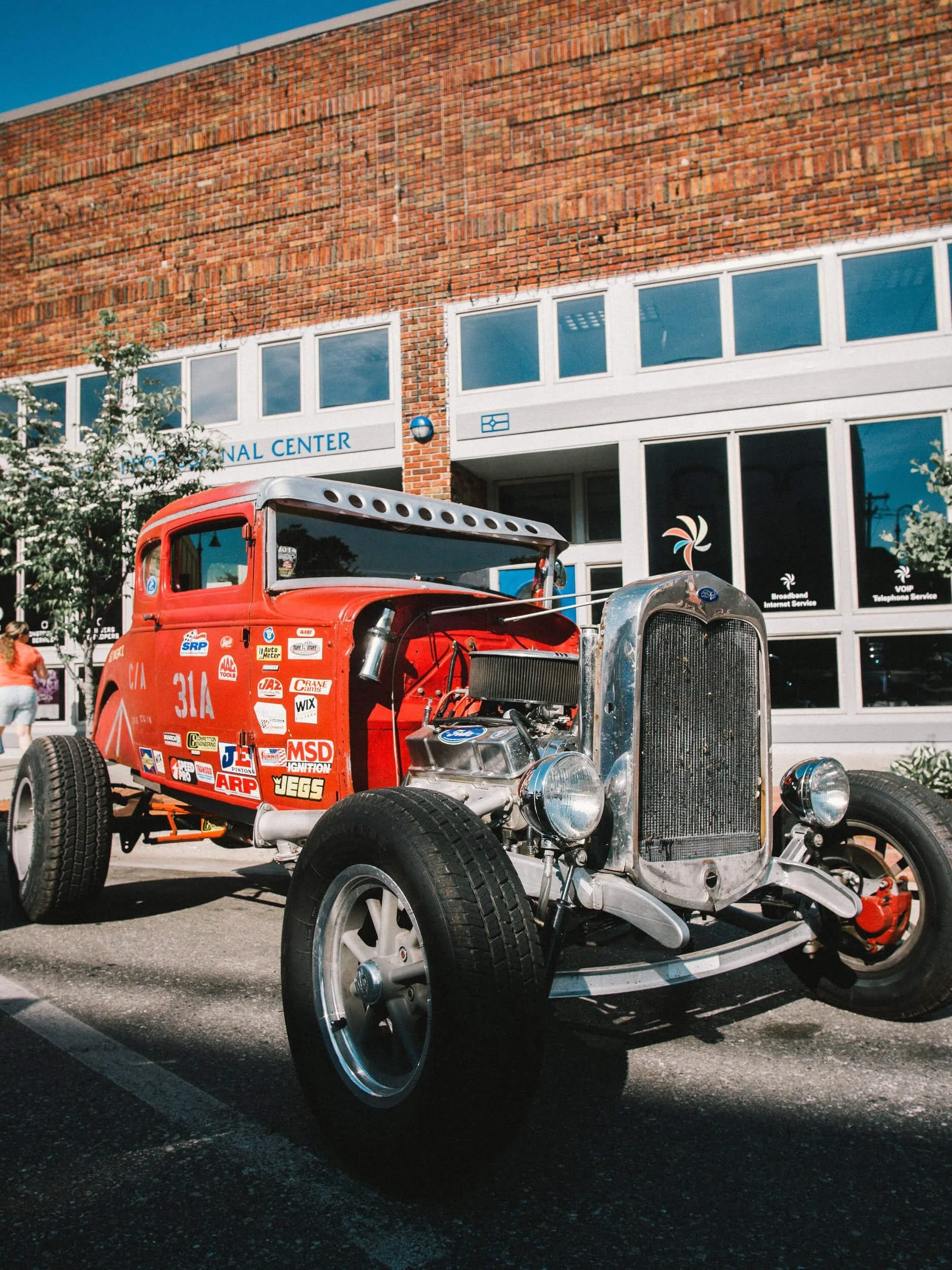 Red and blue vintage hot rod cars displayed at outdoor car show event venue