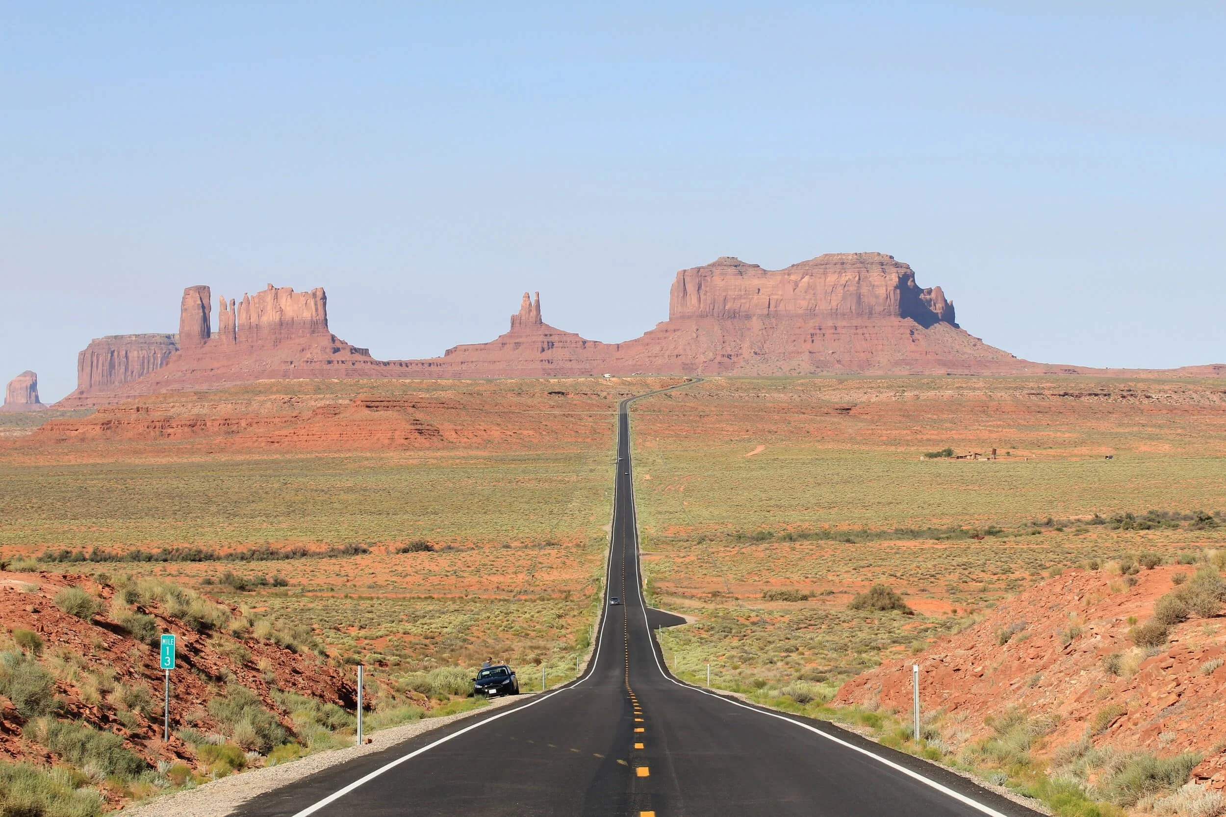 Straight desert highway leading toward red rock formations in Utah, symbolizing smooth vehicle registration renewal process