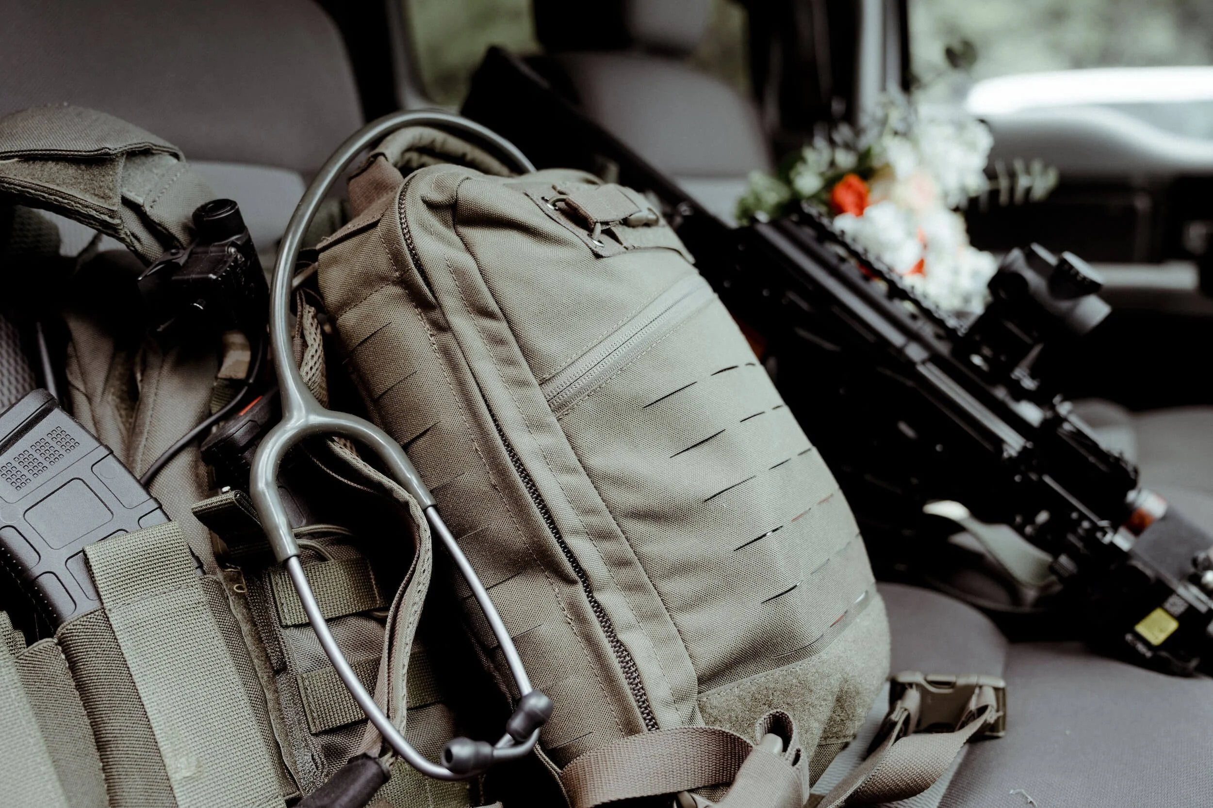 Tactical bugout gear and rifle equipment organized inside military LMTV vehicle interior for emergency preparedness