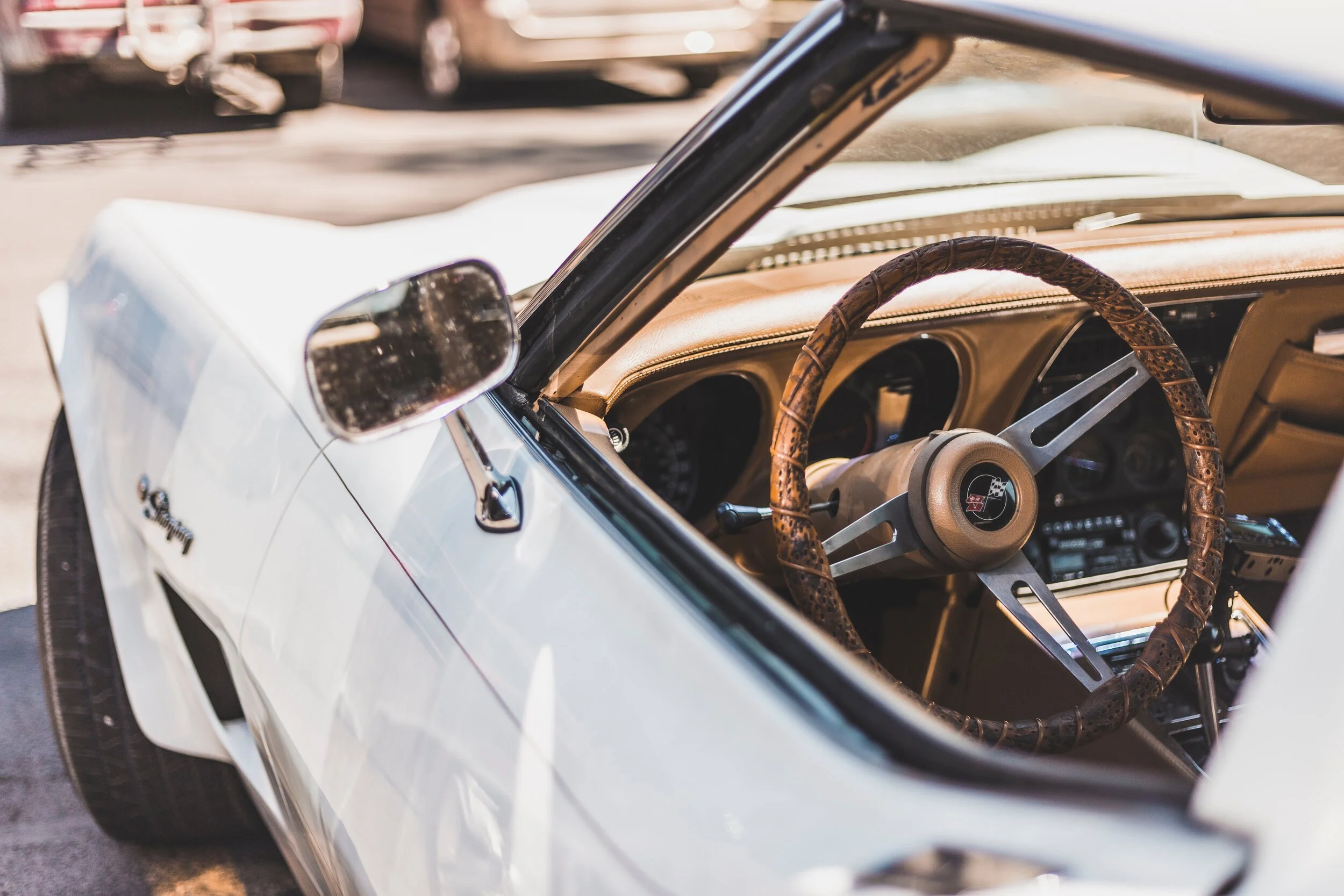 Classic white convertible car interior with vintage steering wheel and dashboard