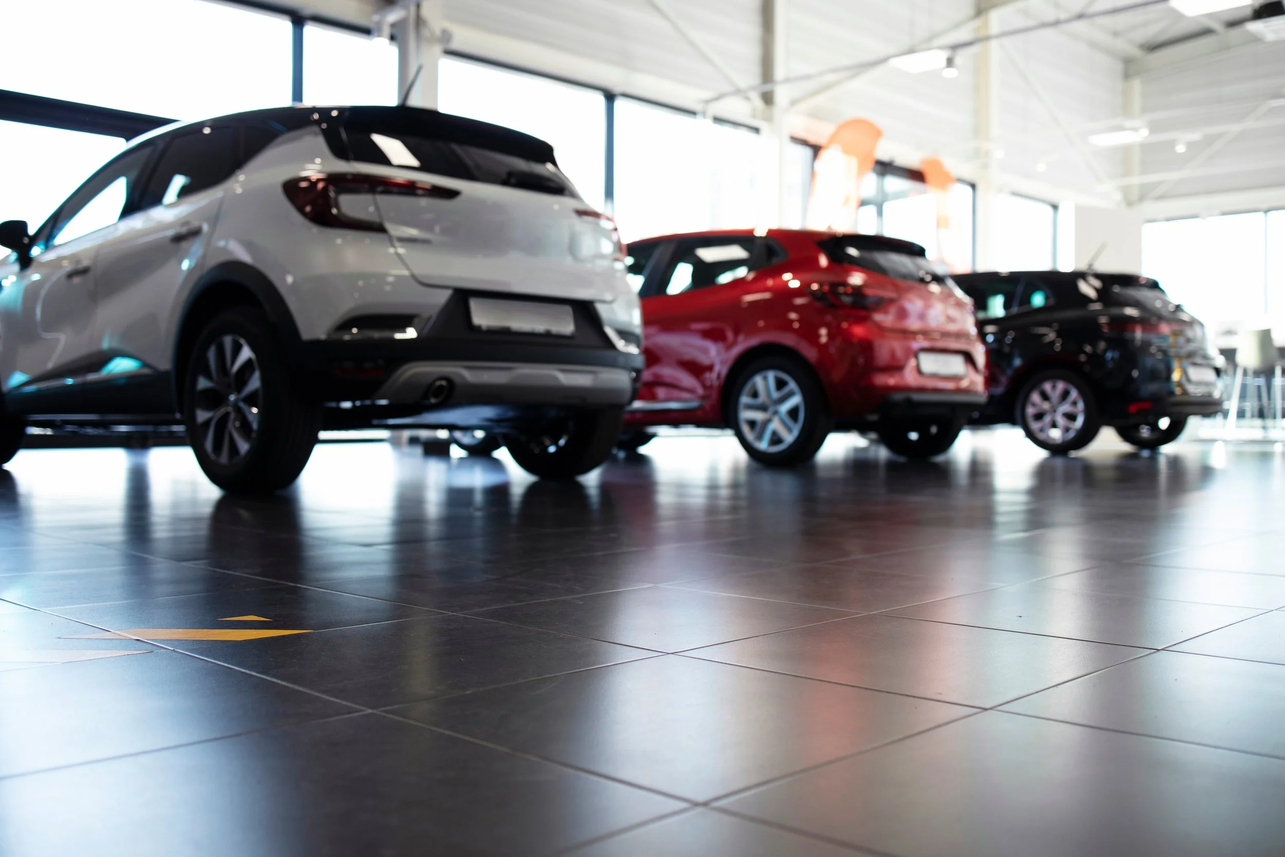 Three colorful cars displayed in modern showroom, helping buyers choose the right vehicle for their needs