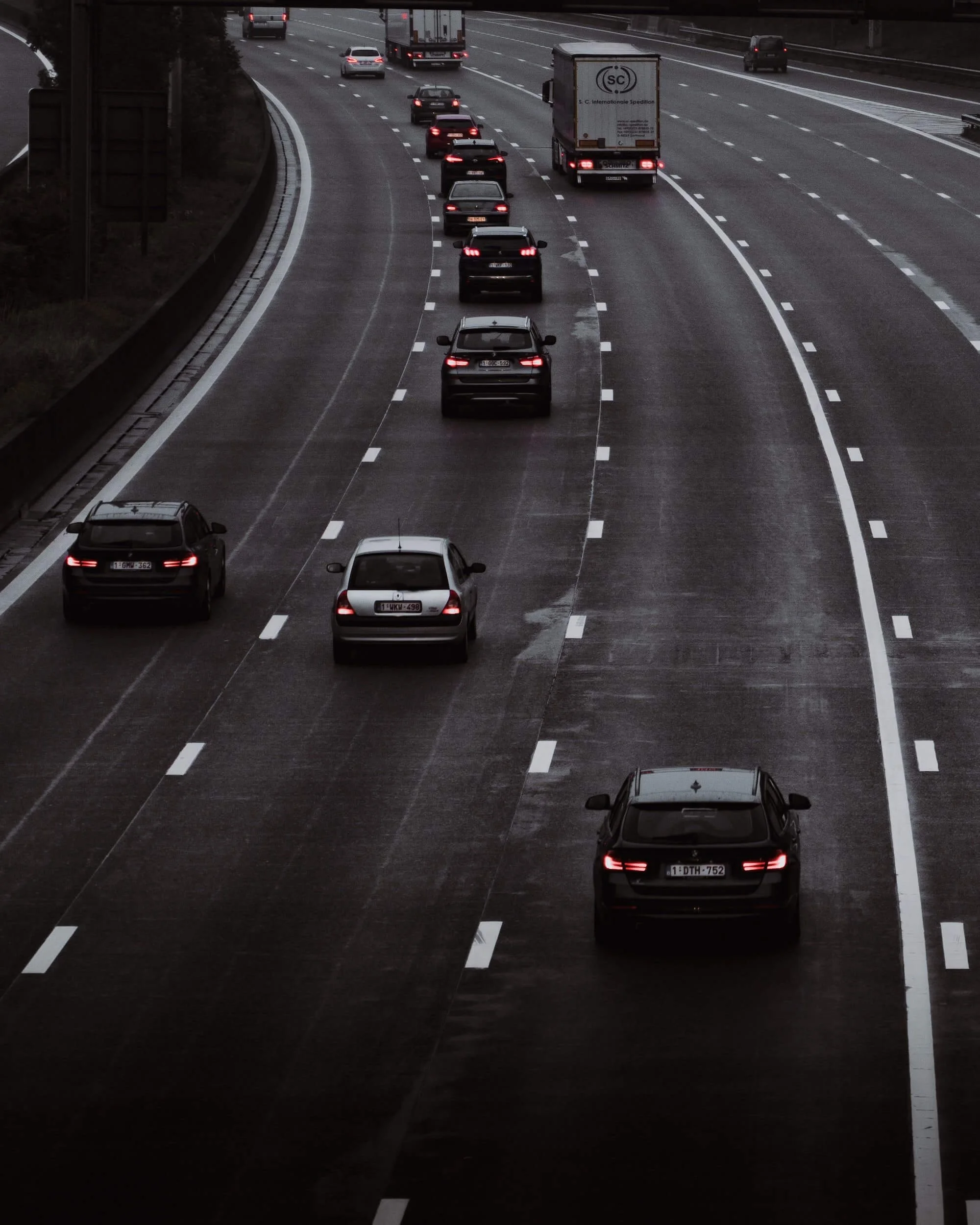 Cars on highway with emissions test topic, vehicles in traffic lanes on wet road pavement