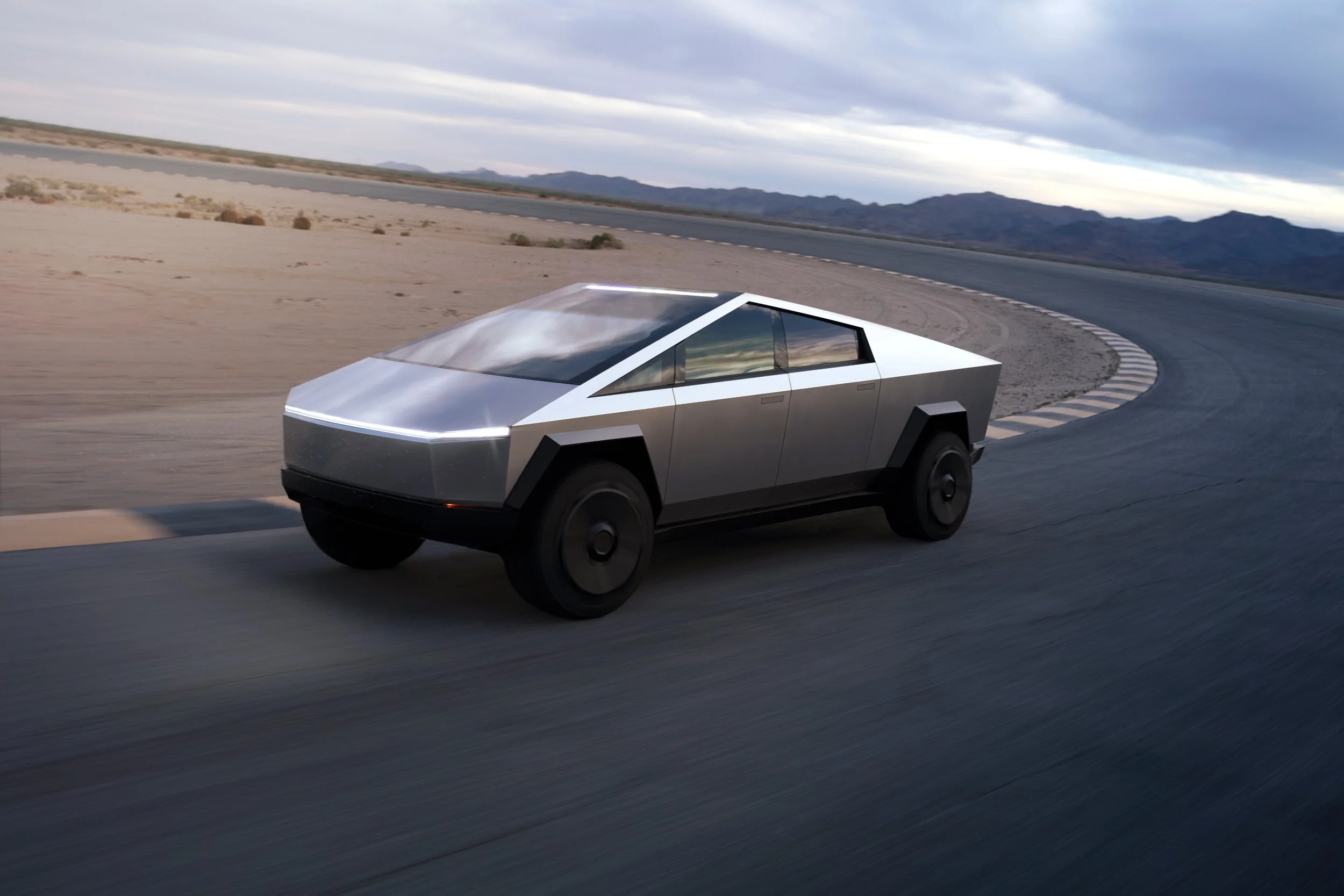 Tesla Cybertruck electric pickup truck driving on desert road
