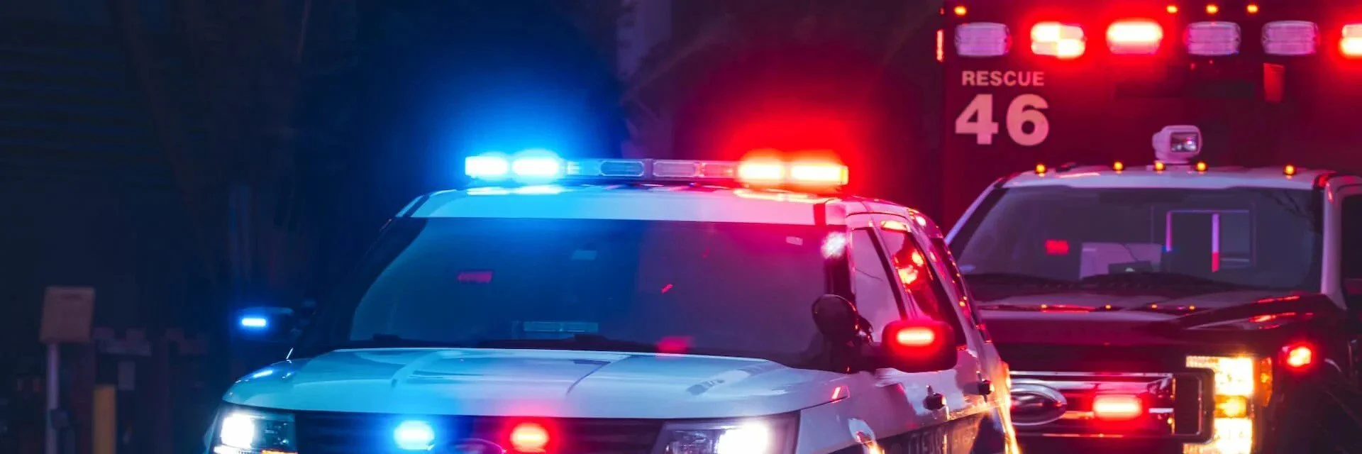 Emergency vehicles with flashing blue and red lights at night
