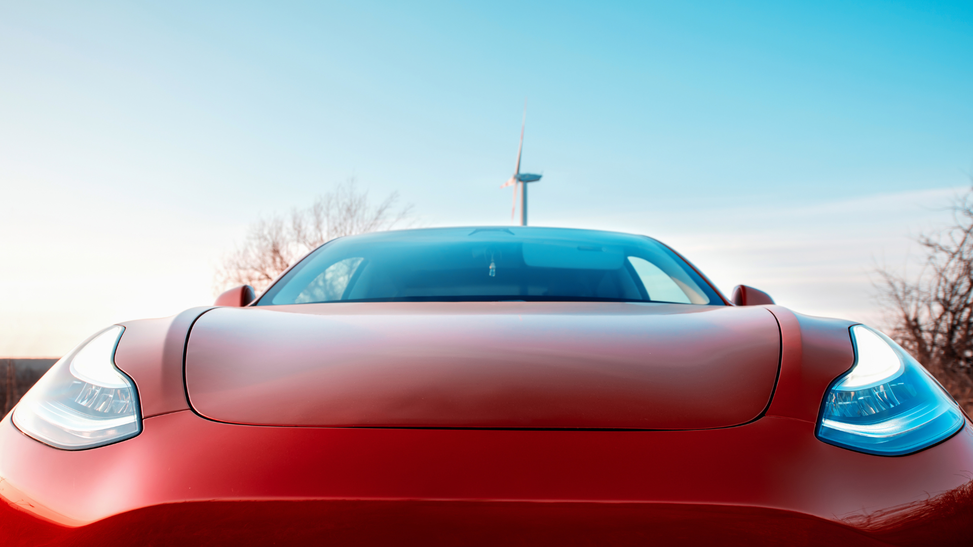 Red Tesla electric vehicle photographed outdoors, representing auto manufacturer facing workplace safety citations from U.S.