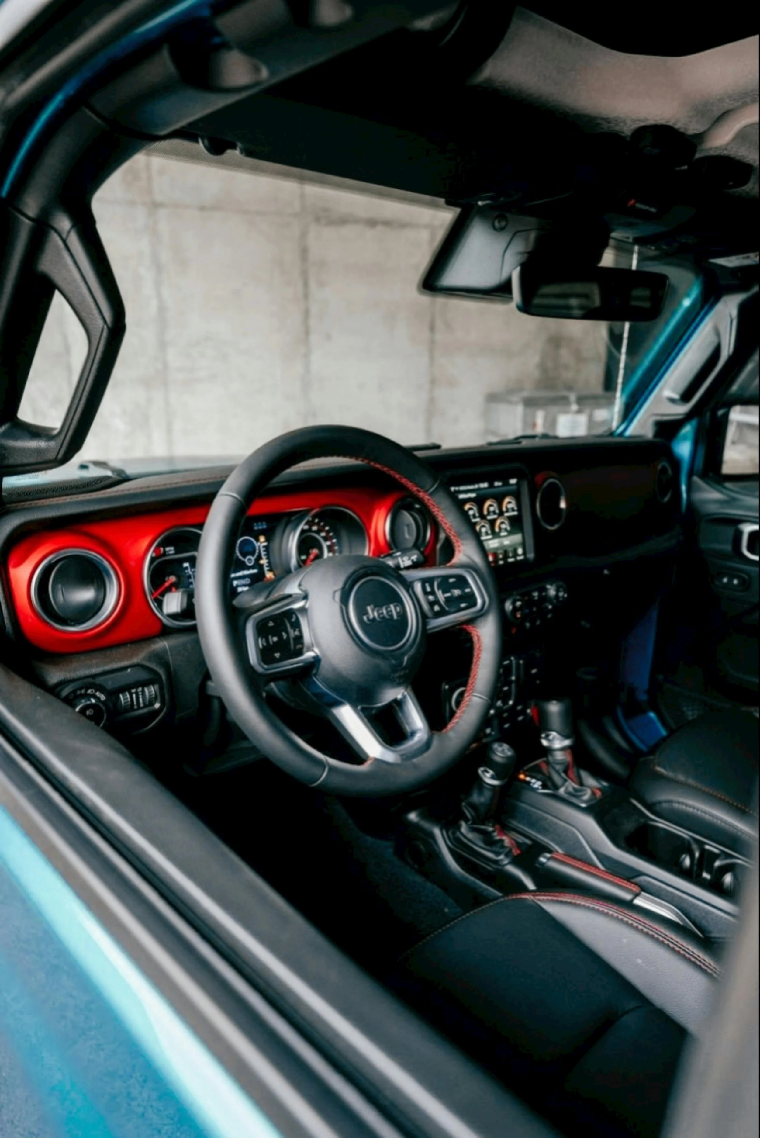 Jeep Wrangler interior dashboard with red accents and modern steering wheel displaying STLA AutoDrive automated driving