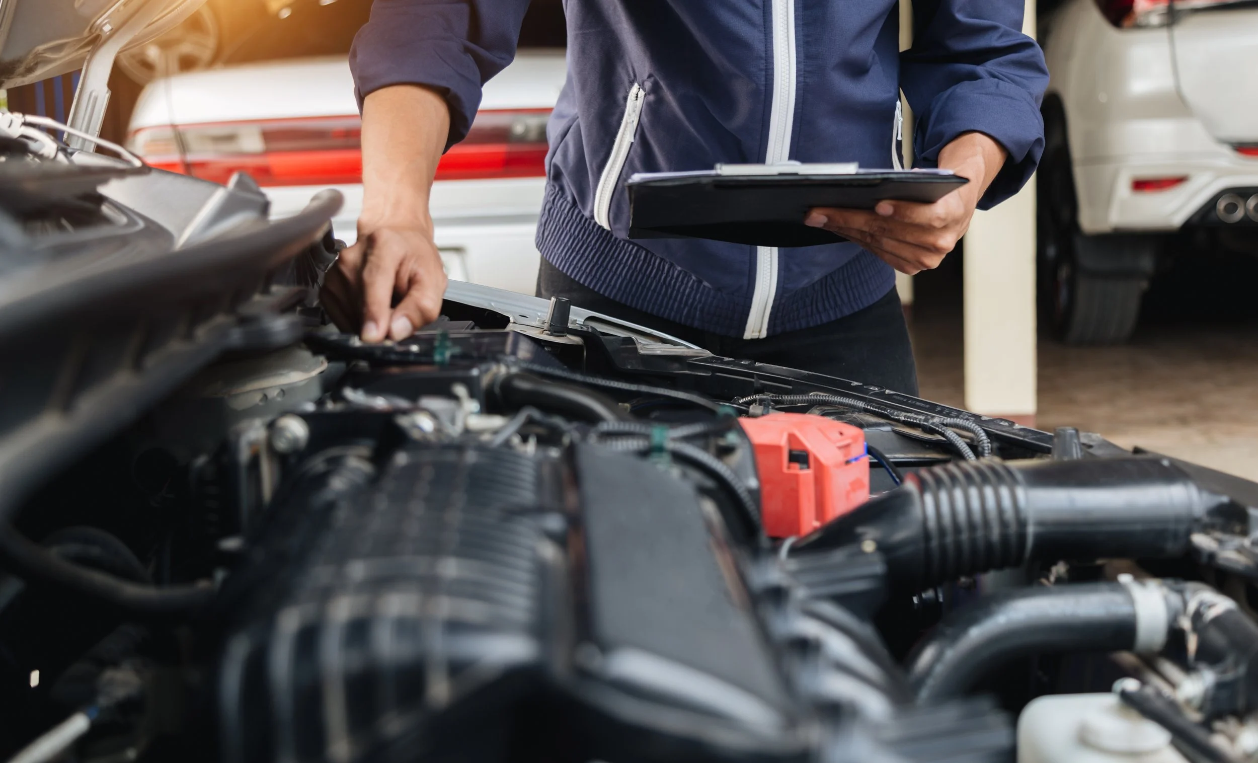 Mechanic inspecting car engine at service station, checking vehicle maintenance for safety and road readiness