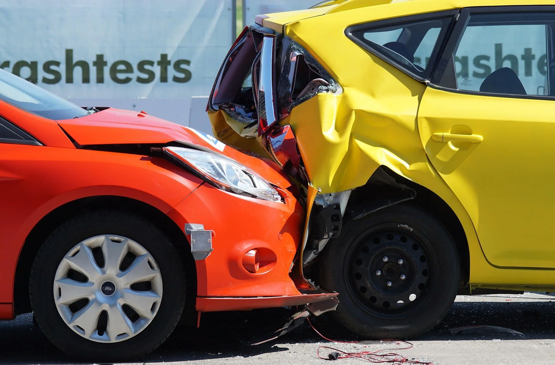 Red and yellow cars in severe crash collision demonstrating need for vehicle insurance coverage