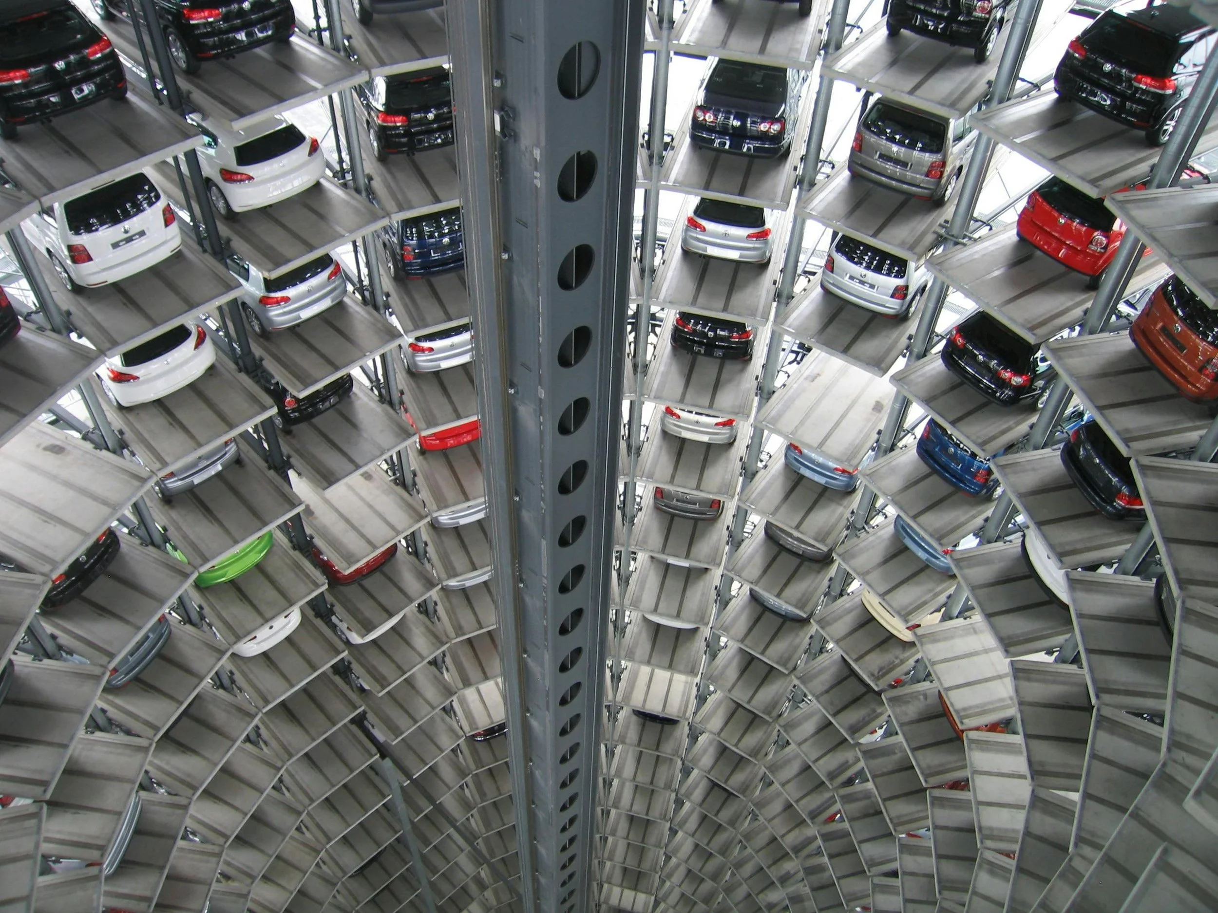 Automated car parking tower filled with stacked vehicles displaying Montana LLC tax strategy benefits for buyers.