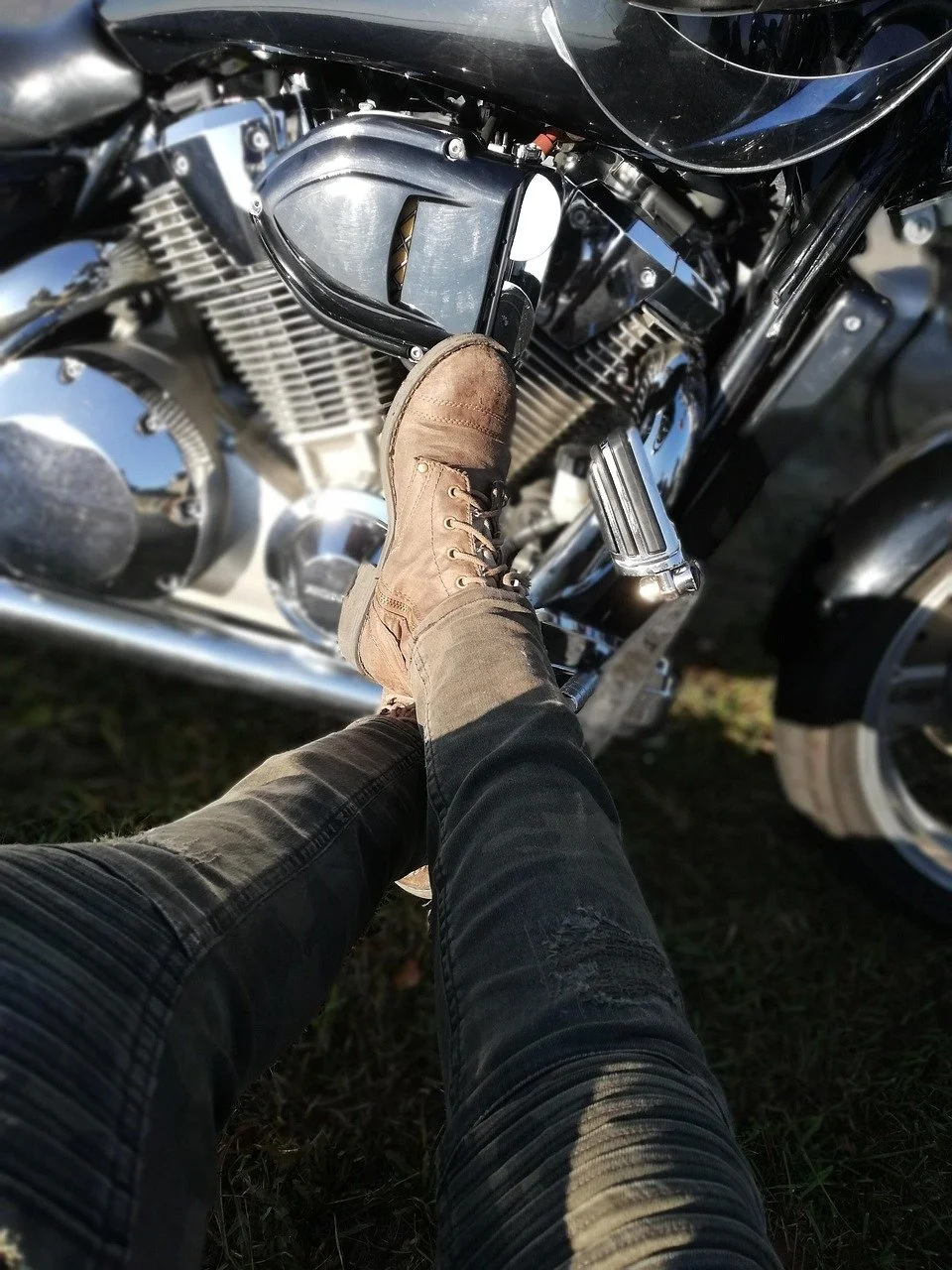 Rider's boot on motorcycle footpeg during outdoor bike ride, representing motorcycle ownership and riding lifestyle.