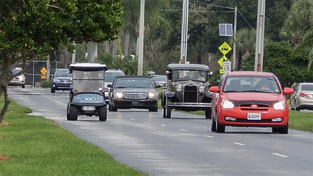 golf cart on street with other vehicles