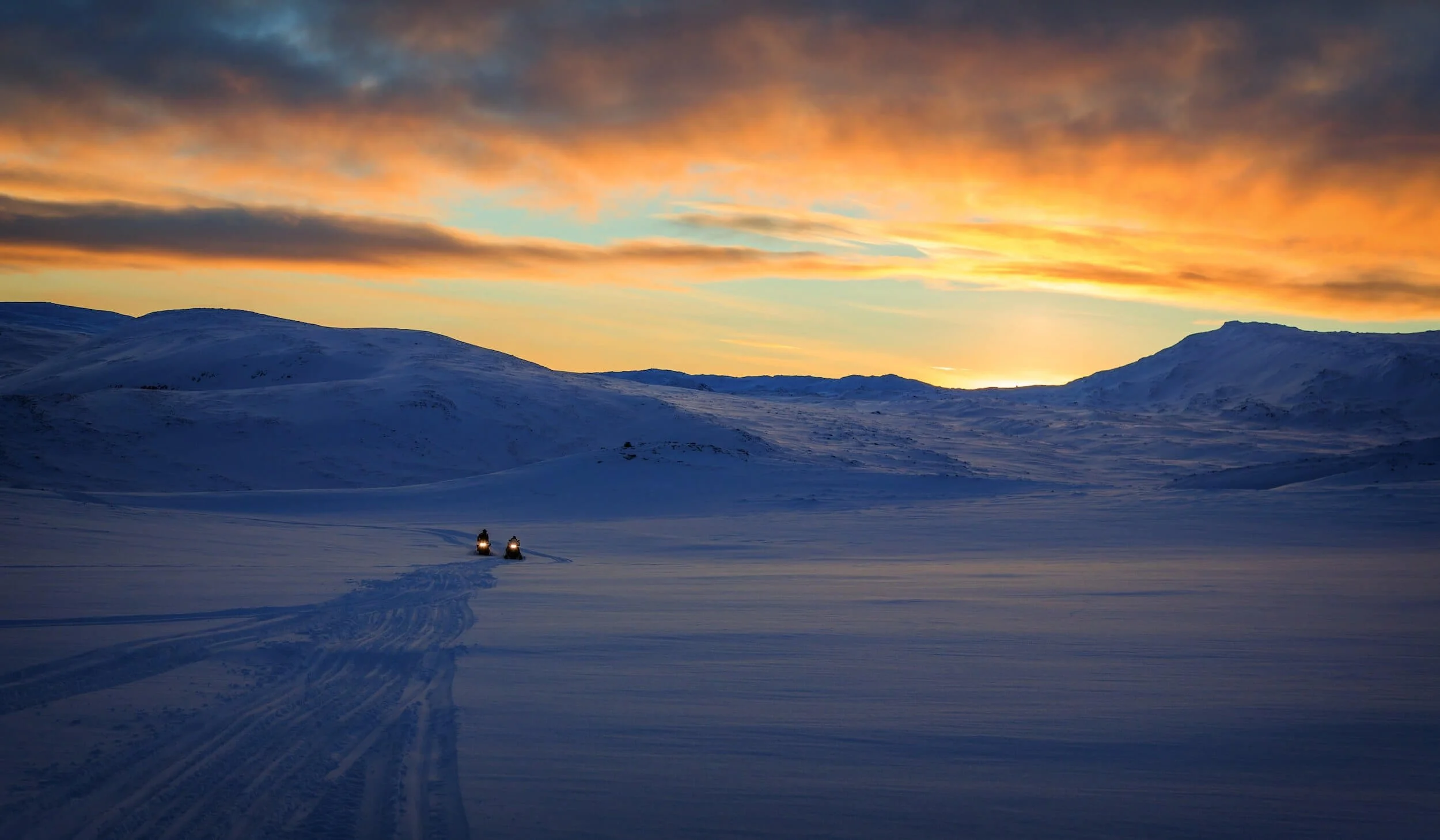 snowmobiles in snow covered mountain