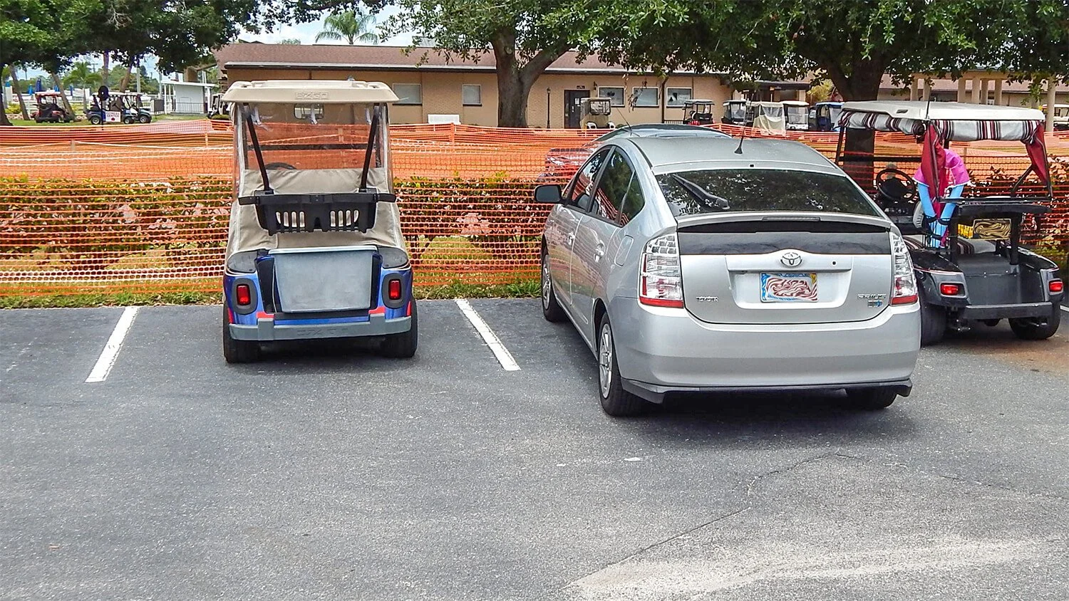 golf cart parked beside car