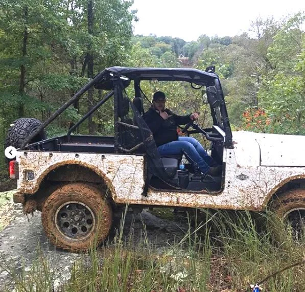 man sitting inside a dirty mahindra roxor