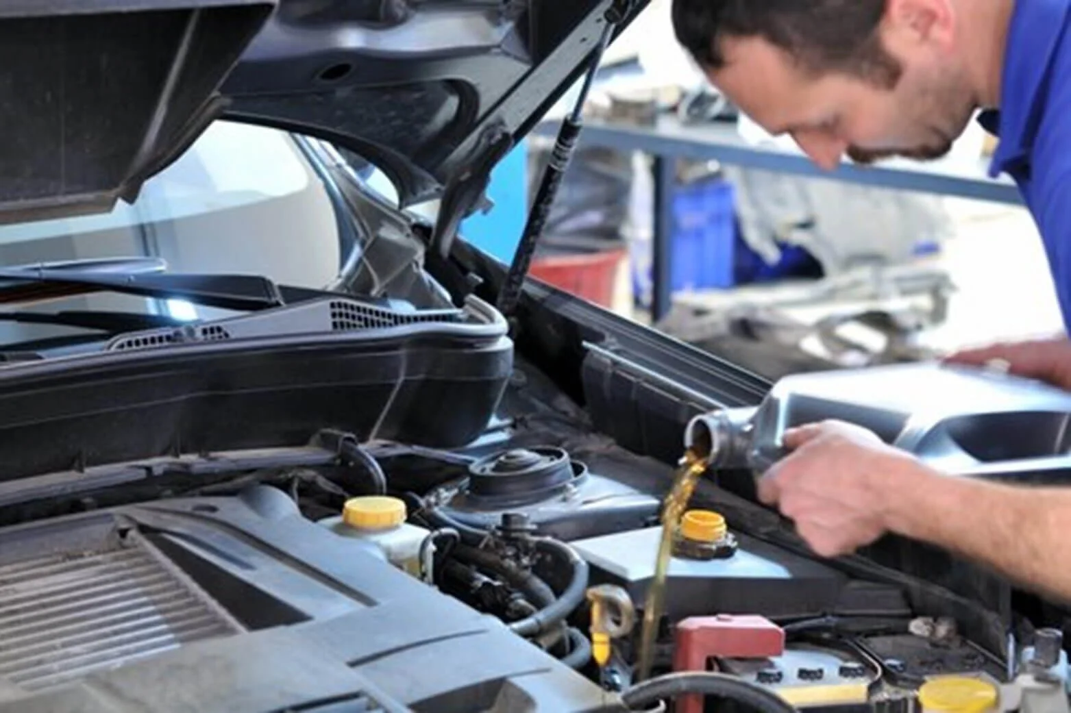 mechanic pouring car oil