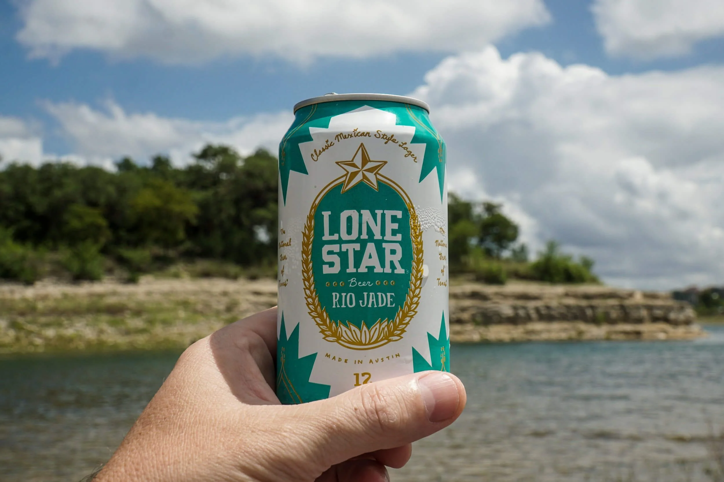 Man's hand holding a sweating cold Lone Star beer
