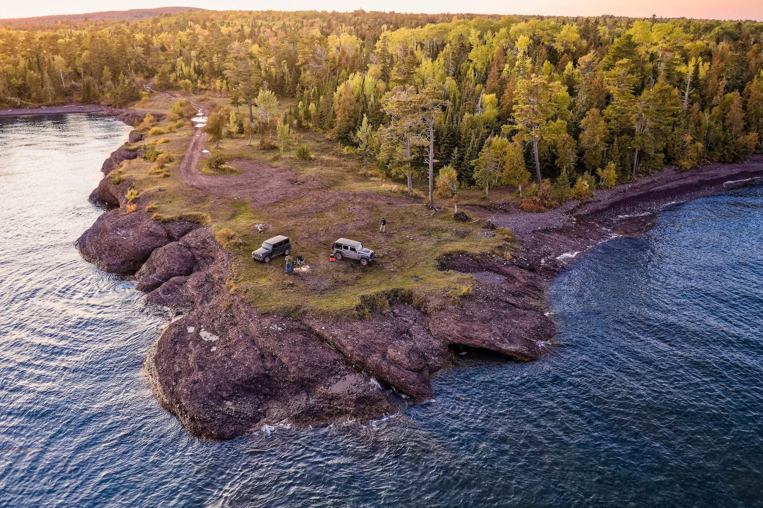 two vehicles on cliff in a remote area