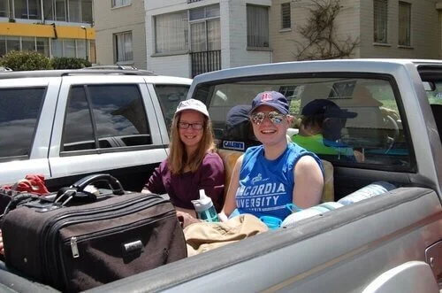 man and woman riding truck bed